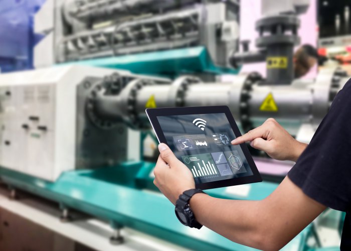 Smart industry control concept.Hands holding tablet on blurred automation machine as background Smart industry control concept.Hands holding tablet on blurred automation machine as background